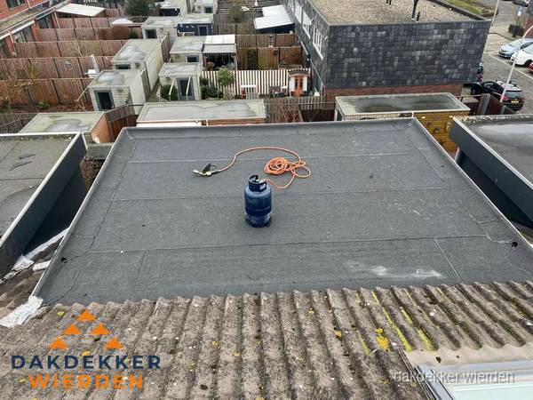 Plat dak met nieuwe bitumen dakbedekking en brandgereedschap in Wierden