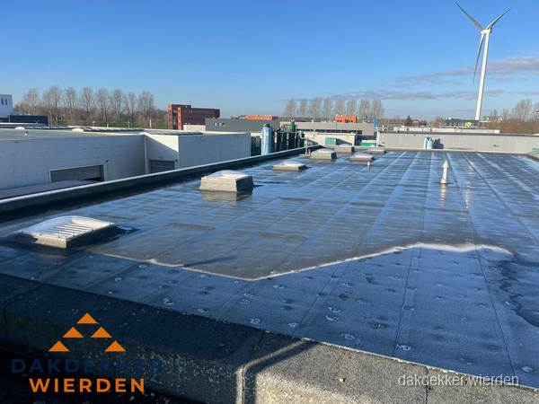 Plat dak bedrijfspand met bitumen dakbedekking en lichtkoepels in Wierden