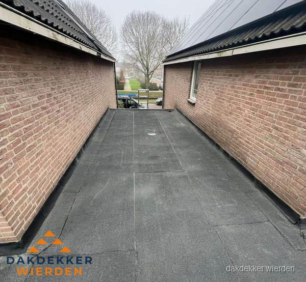 Plat dak met bitumen dakbedekking tussen bakstenen muren in Wierden Plat dak met bitumen dakbedekking tussen bakstenen muren in Wierden