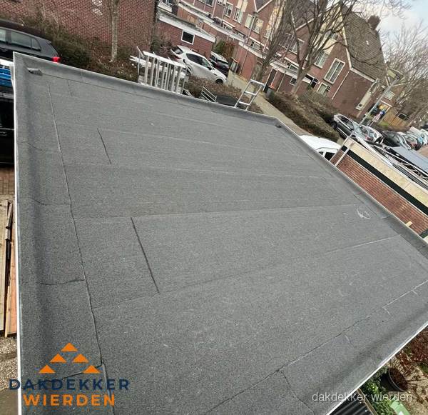 Nieuwe bitumen dakbedekking op plat dak van garage in Wierden