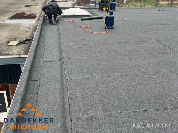 Dakdekker repareert bitumen dakbedekking op groot plat dak in Wierden Dakdekker repareert bitumen dakbedekking op groot plat dak in Wierden