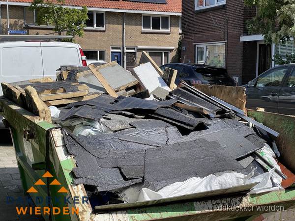 Afvalcontainer met gesloopt dakmateriaal tijdens dakkapel renovatie in Wierden Afvalcontainer met gesloopt dakmateriaal tijdens dakkapel renovatie in Wierden