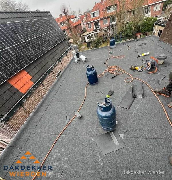 Daklekkage repareren met brandgereedschap op plat dak in Wierden
