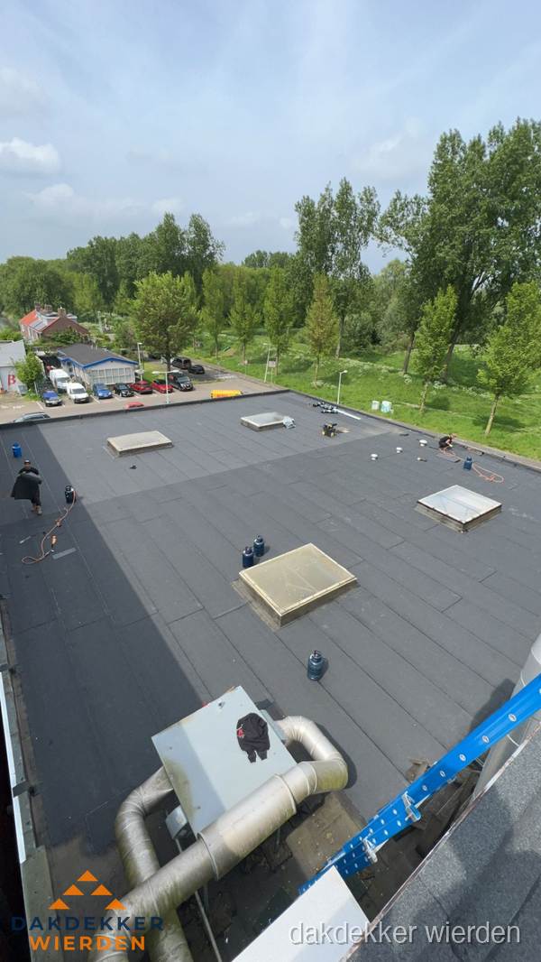 Dakdekker aan het werk op groot plat dak met bitumen in Wierden Dakdekker aan het werk op groot plat dak met bitumen in Wierden